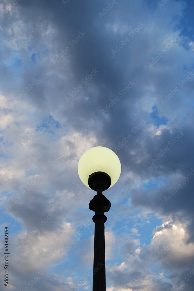 Street lamp at dusk on blue cloudy sky background