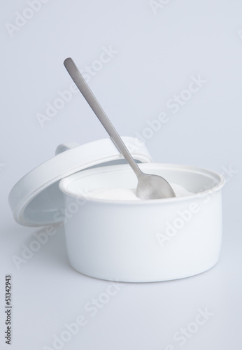 White sugar container with silver spoon