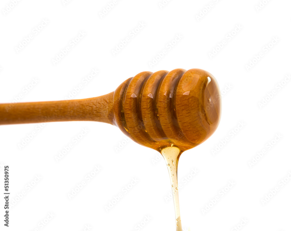 Honey dripping from a wooden honey dipper Honey dripping from a wooden honey dipper