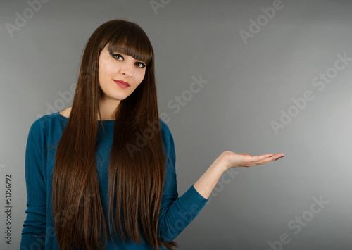 Business woman with her hand open to show a product isolated on