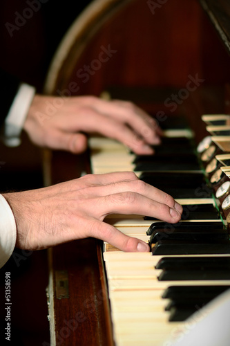 Male hands playing on piano