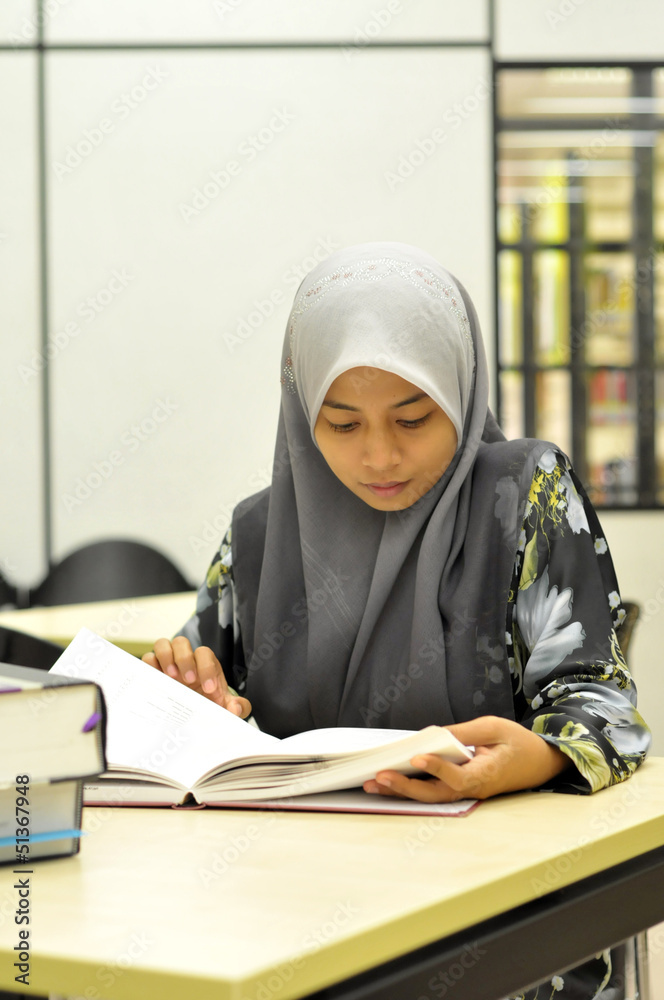 Young Muslim student studying in the library Young Muslim student studying in the library