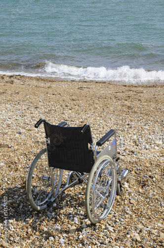 Wheelchair on a seaside pebble beach