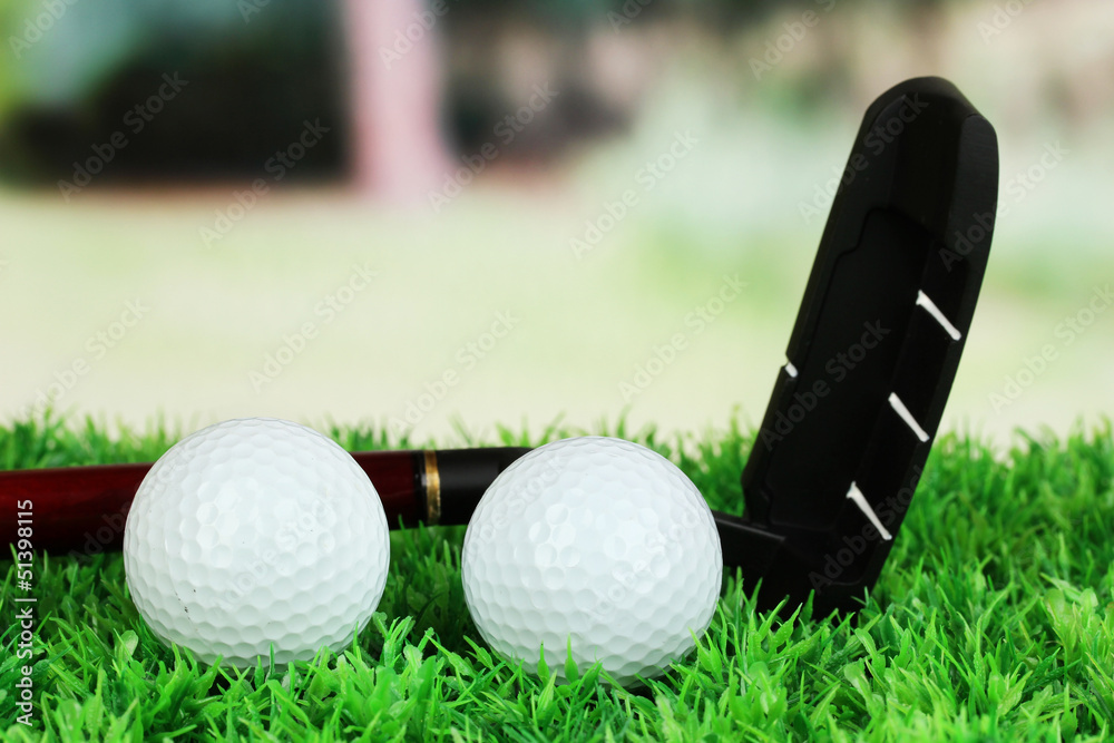 Naklejka premium Golf balls and driver on green grass outdoor close up
