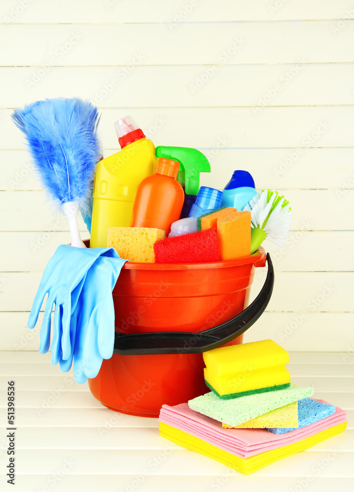 Cleaning items in bucket on white wooden background Cleaning items in bucket on white wooden background