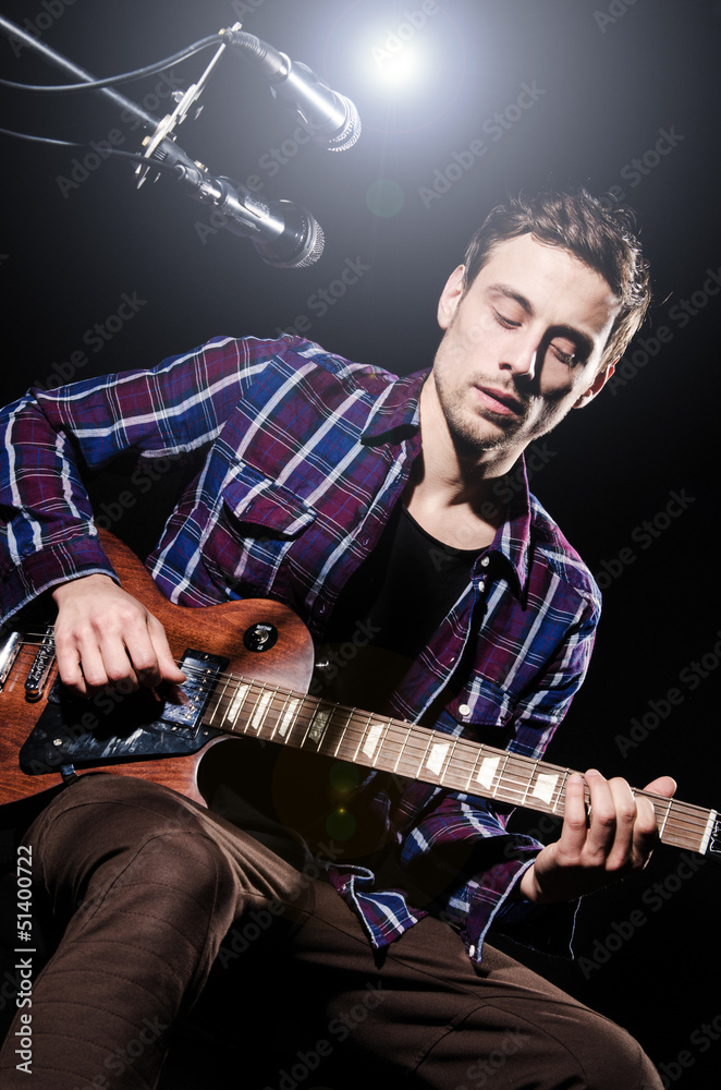 Obraz premium Man playing guitar during concert