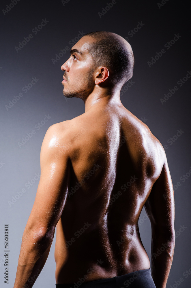 Fototapeta premium Muscular man in dark studio
