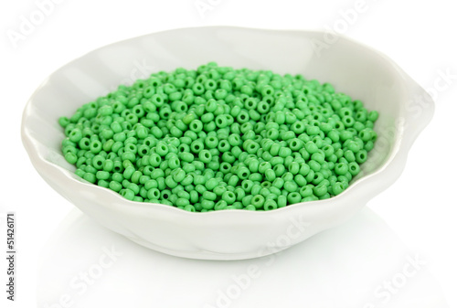 Green beads in white plate isolated on white