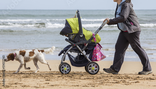 Madre con cochecito bebe por la playa