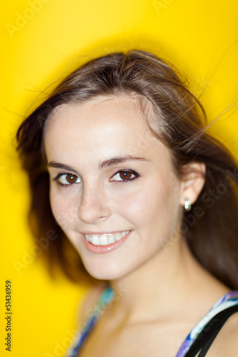 Handsome woman smiling at camera with yellow background