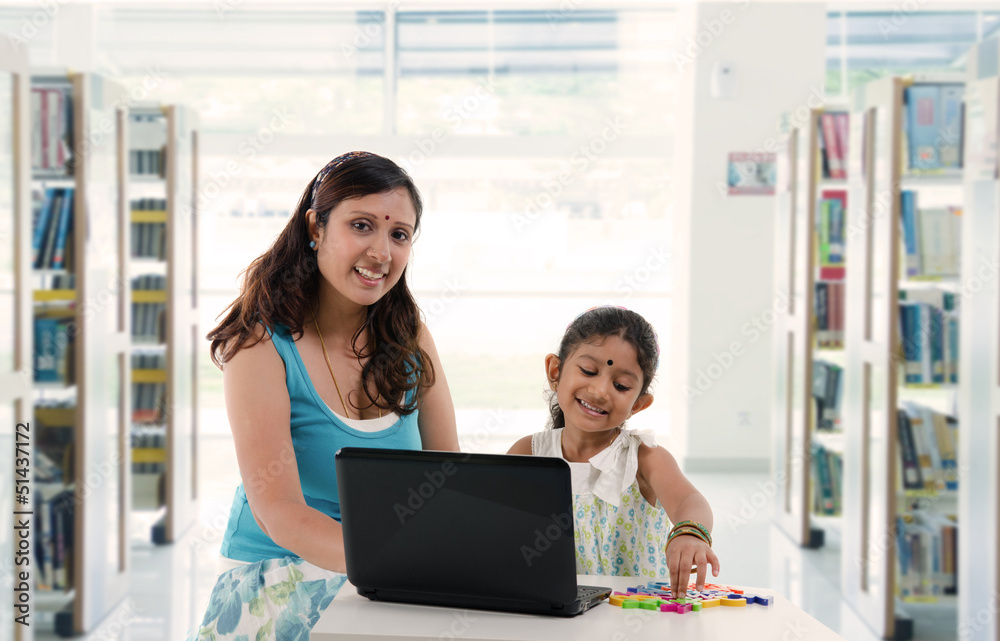 mother and daughter with laptop learning inside a library, india mother and daughter with laptop learning inside a library, india