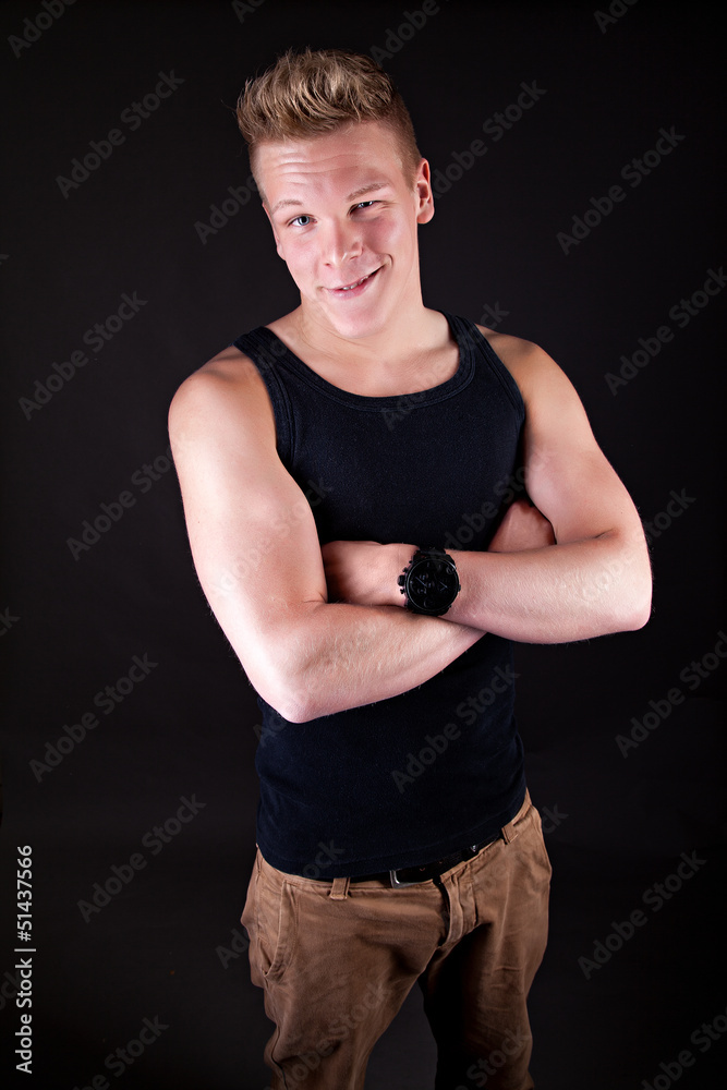 Muscular sexy smiling young cute man posing in a vest