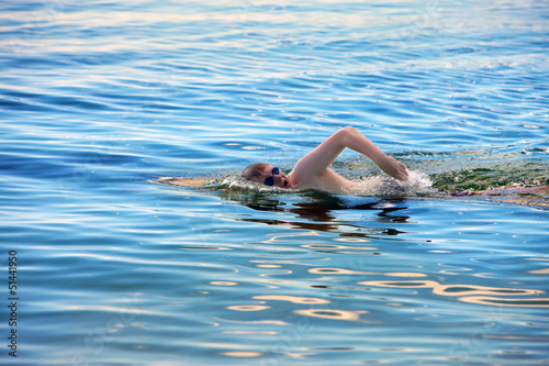  young sporting man swims in the sea