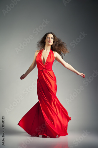 Ballet dancer wearing red dress over grey