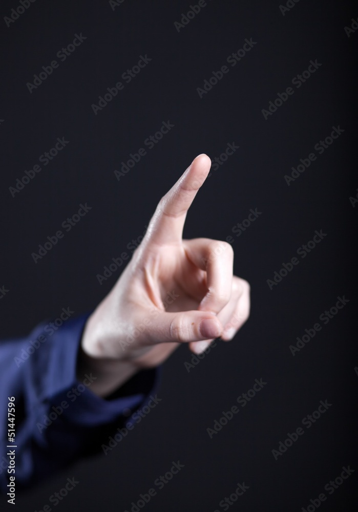 Female hand with finger on dark background Female hand with finger on dark background
