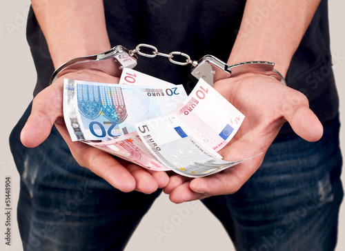 closeup of a man in handcuffs holding money photo