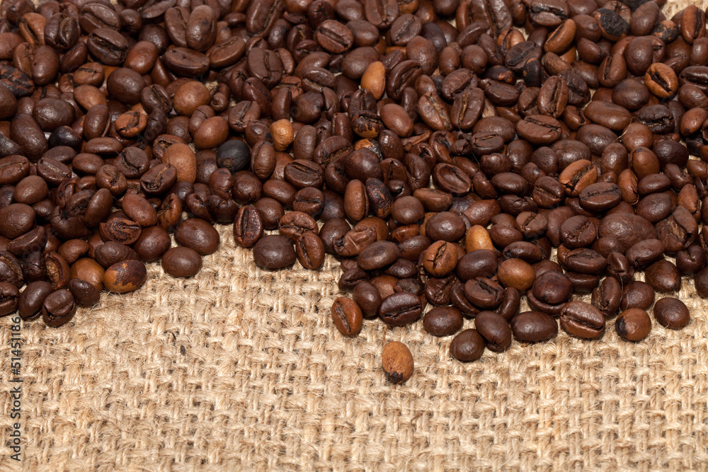 Coffee grains on rough fabric of linen close-up Coffee grains on rough fabric of linen close-up