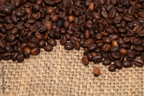 Coffee grains on rough fabric of linen close-up