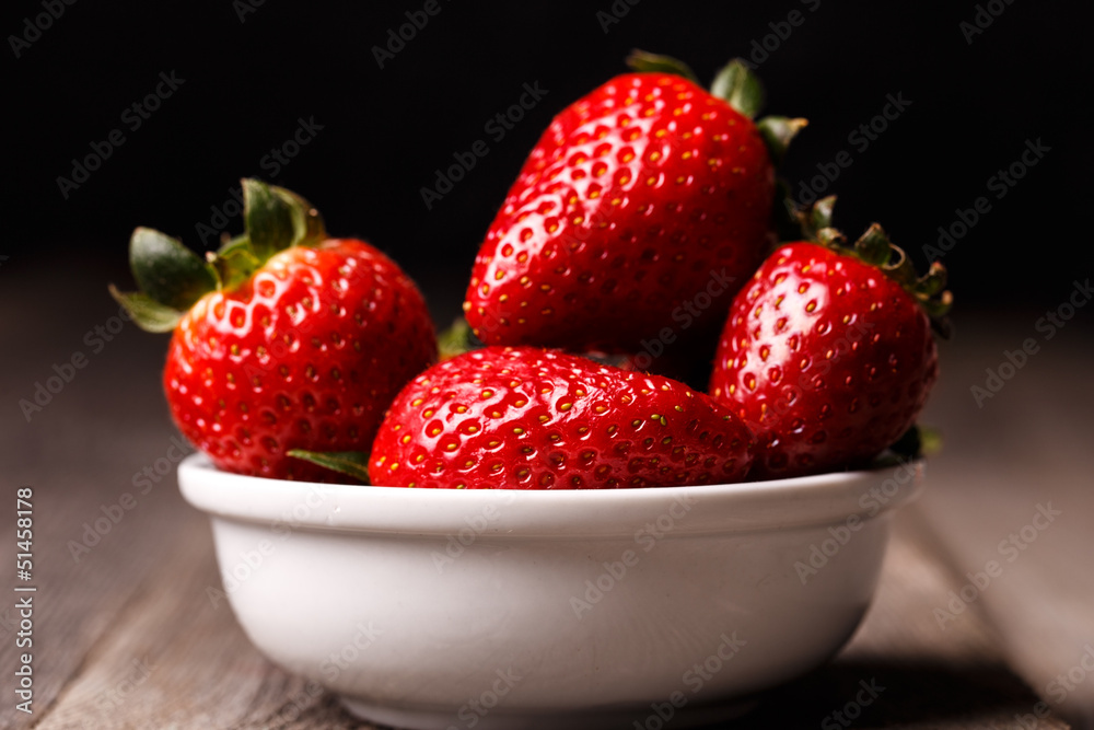 Strawberries in white plate on the old wooden table. Strawberries in white plate on the old wooden table.
