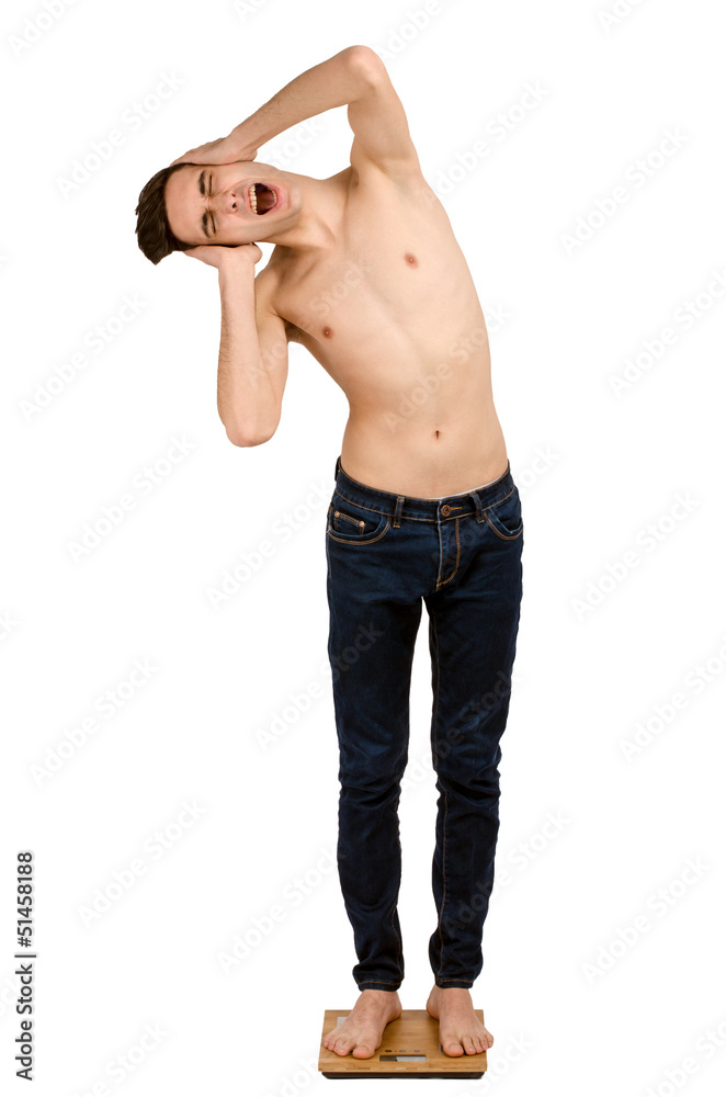 Man weighing himself on scale and scared of how skinny he is. Man weighing himself on scale and scared of how skinny he is.