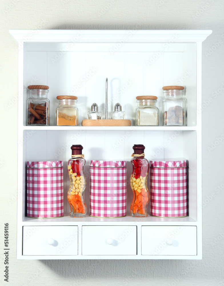 Beautiful white shelves with spices in glass bottles Beautiful white shelves with spices in glass bottles