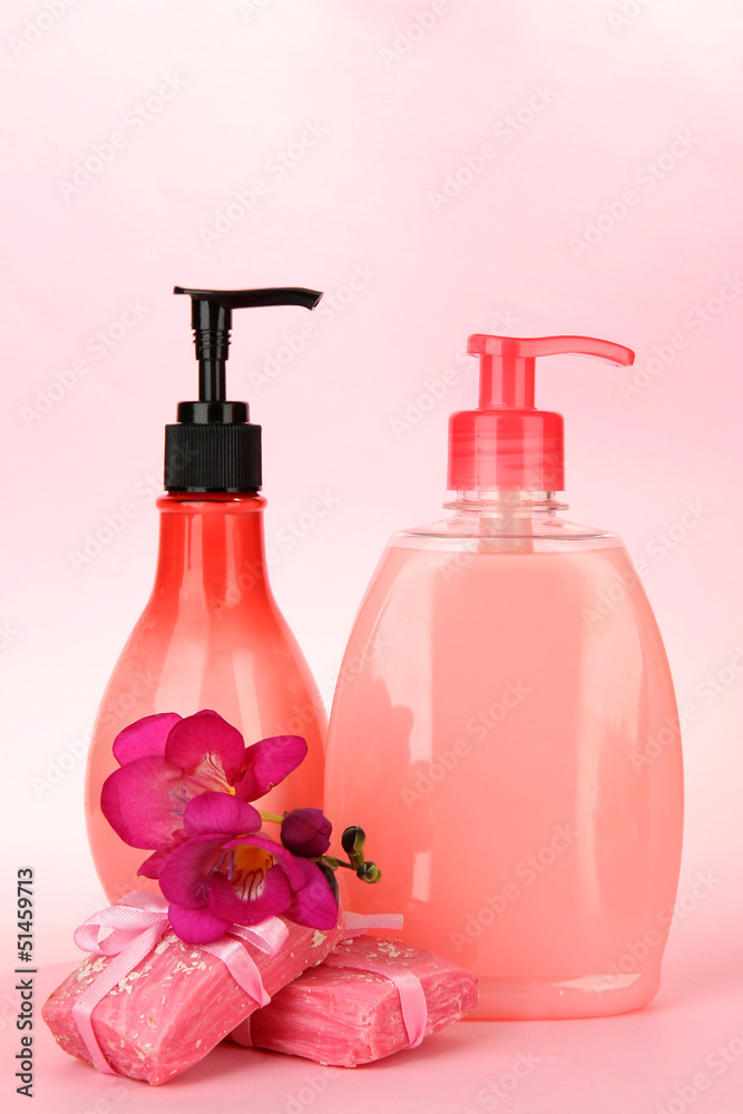 Liquid and hand-made soaps on pink background Liquid and hand-made soaps on pink background