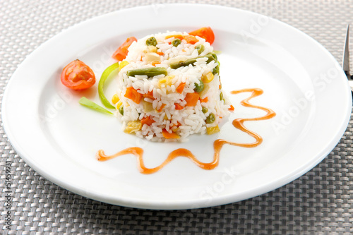 Delicious risotto with vegetables on table