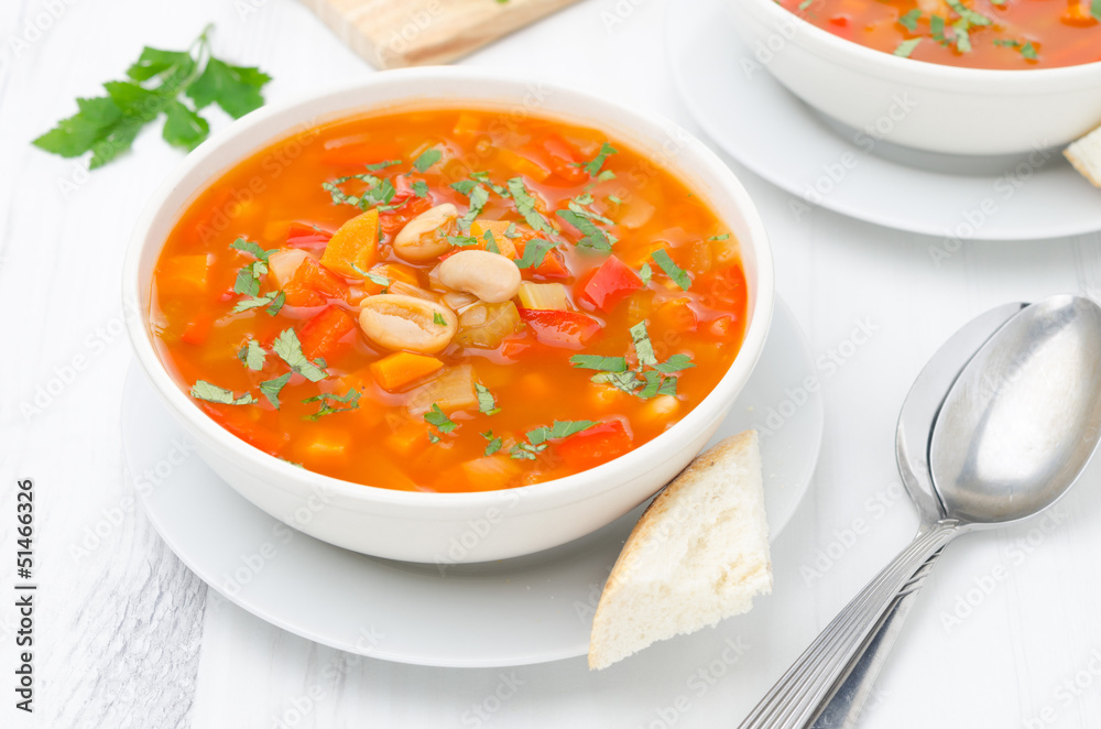 Vegetable soup with white beans in a bowl top view