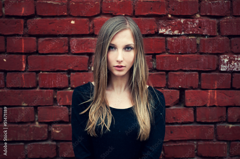 beautiful girl on a background of an old brick wall in red beautiful girl on a background of an old brick wall in red