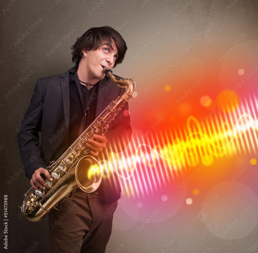 Fototapeta premium Młody mężczyzna grający na saksofonie z kolorowymi falami dźwiękowymi