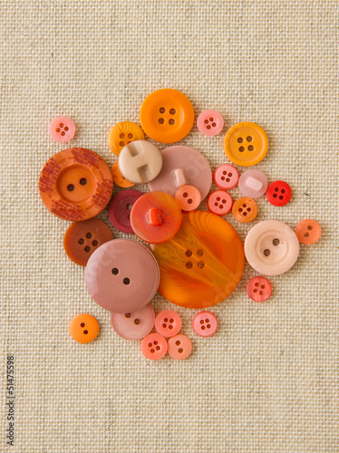Pile of orange buttons on hessian