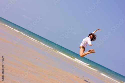 Young lady jumping over the horizon