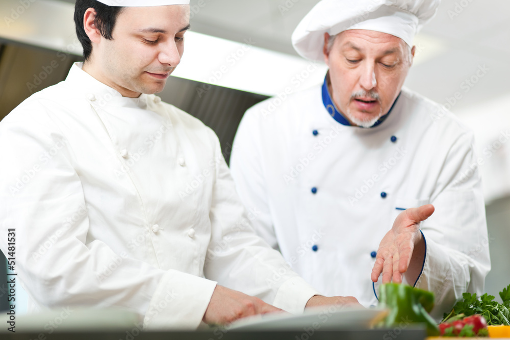 Two chefs cooking in a kitchen