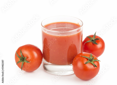 Glass of tomato juice and tomatoes on a white background