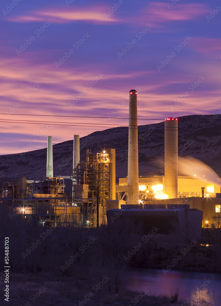 Power plant at sunrise with smoke stacks and steam Power plant at sunrise with smoke stacks and steam