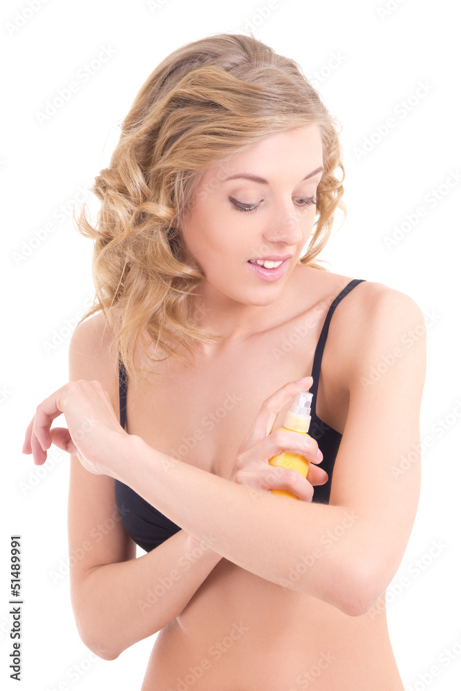 young blond spraying lotion on her shoulder young blond spraying lotion on her shoulder