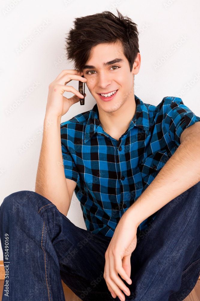 Young man talking on the phone at home Young man talking on the phone at home