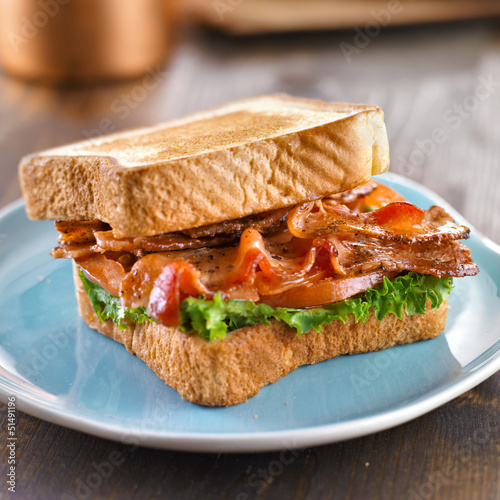 BLT bacon lettuce tomato sandwich with toast off to the side.
