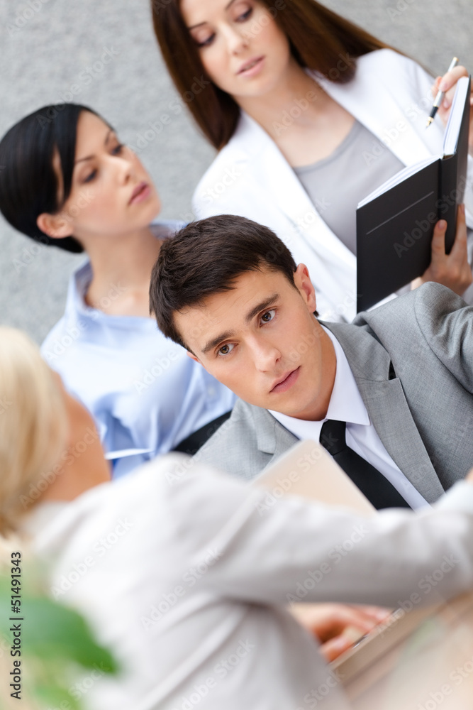 Businessman at the meeting with his pretty employees Businessman at the meeting with his pretty employees