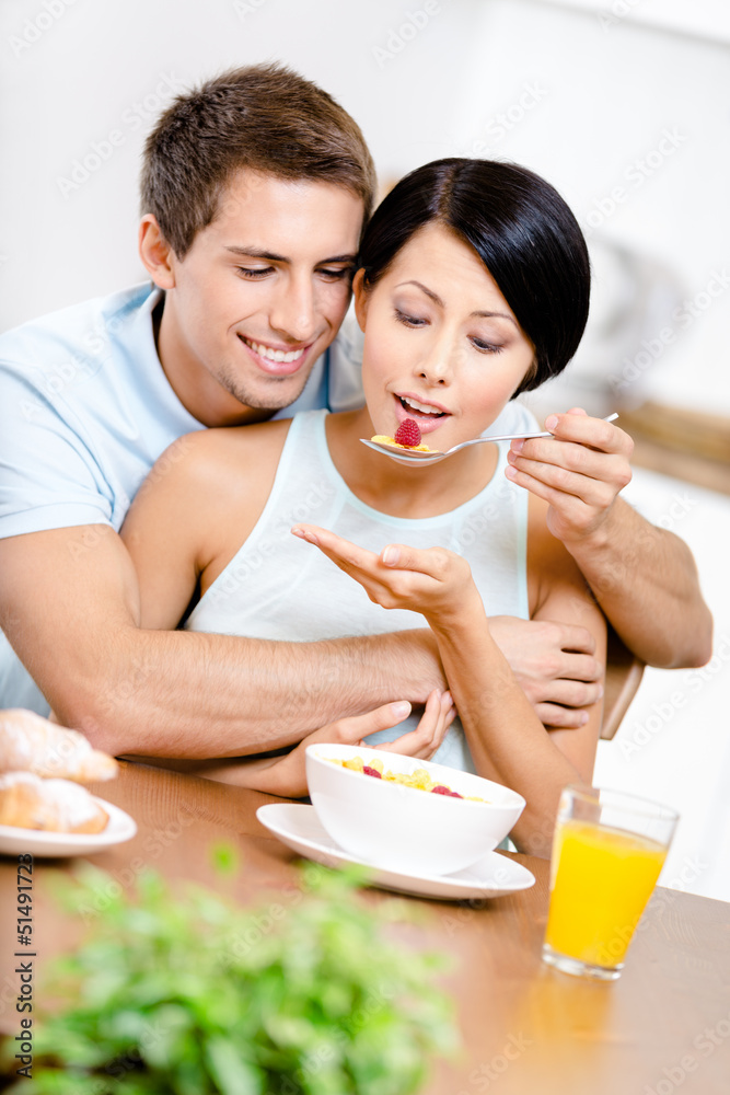 Male feeds and hugs his girlfriend sitting at the Male feeds and hugs his girlfriend sitting at the