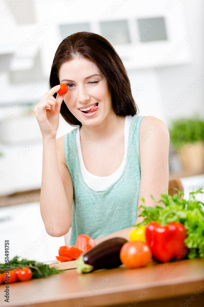 Woman keeps tomato sitting at the table 