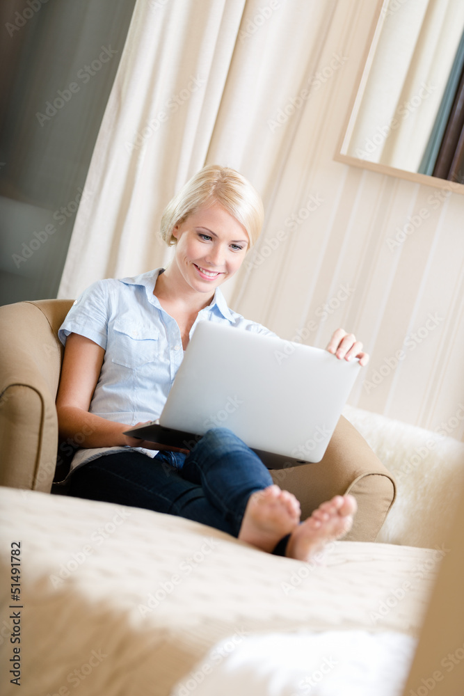 Woman sitting on the sofa with silver pc Woman sitting on the sofa with silver pc