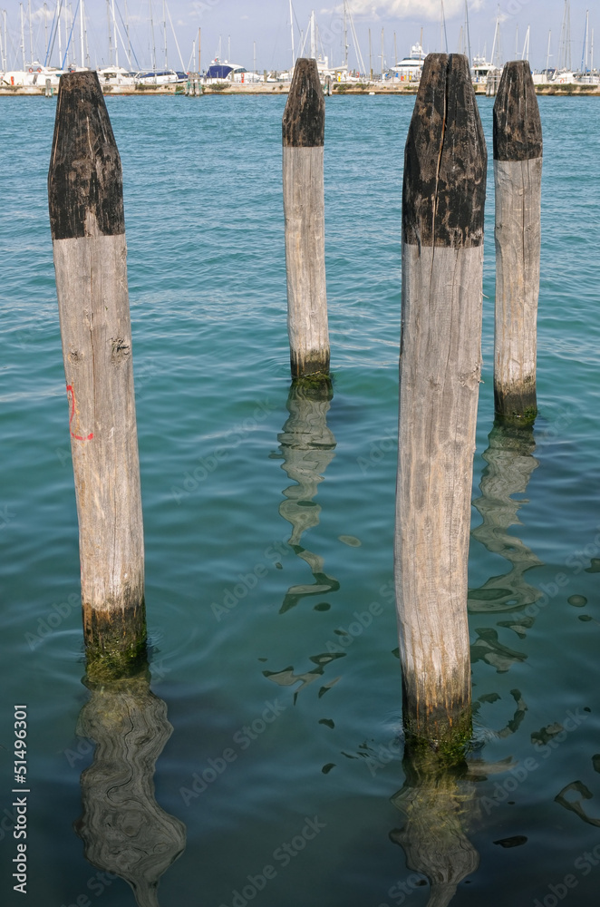 Wooden bollards in a nautical landing place Wooden bollards in a nautical landing place