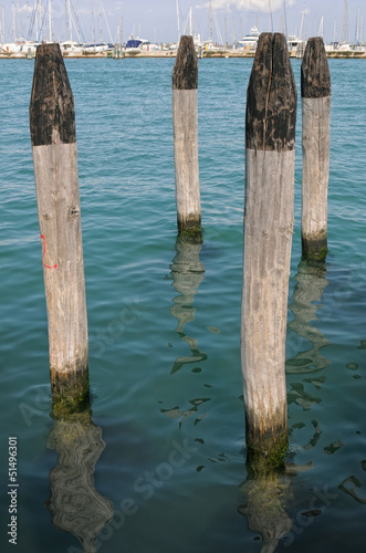 Wooden bollards in a nautical landing place © VeSilvio