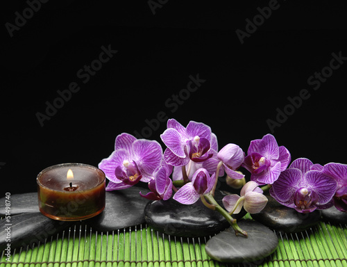 branch orchid with zen stone and candle on mat