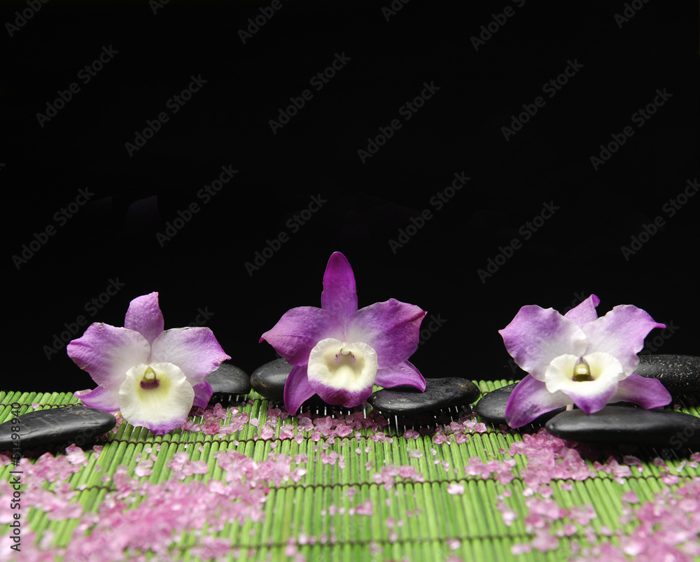 Set of pink orchid with zen stone and many salt on green mat Set of pink orchid with zen stone and many salt on green mat