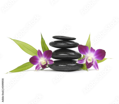 Stacked zen stones with pink orchid and bamboo leaf