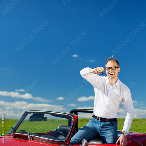lachender mann zeigt autoschlüssel
