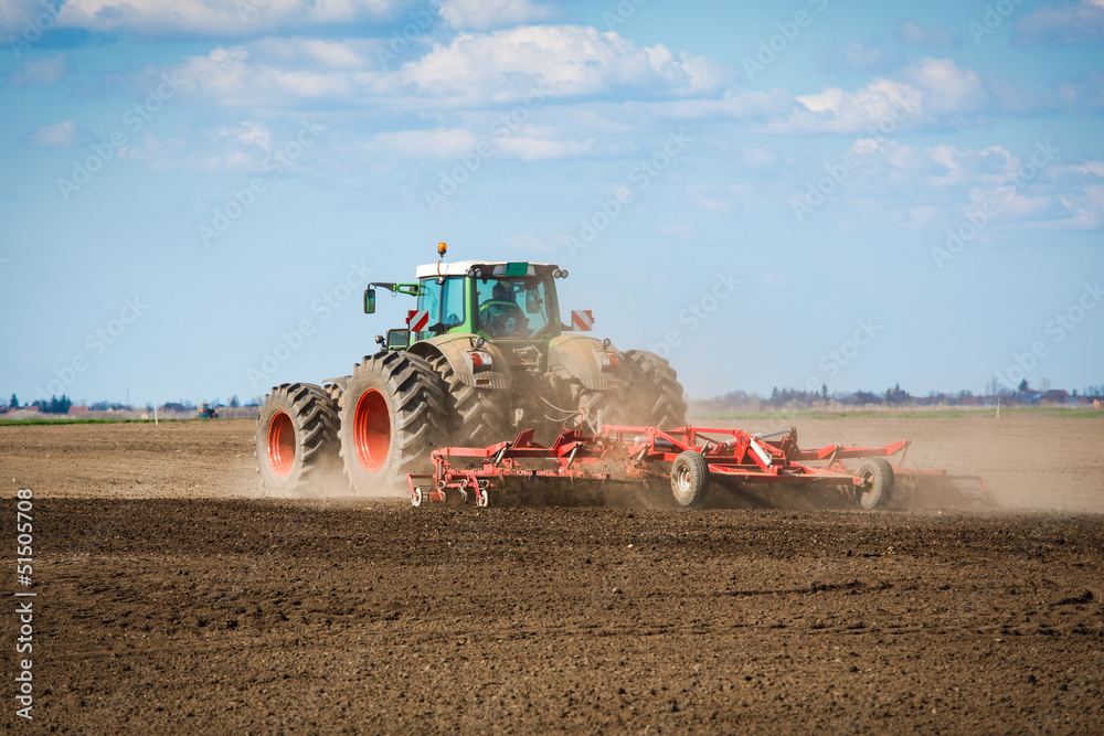 Fototapeta premium Tractor in the field sow