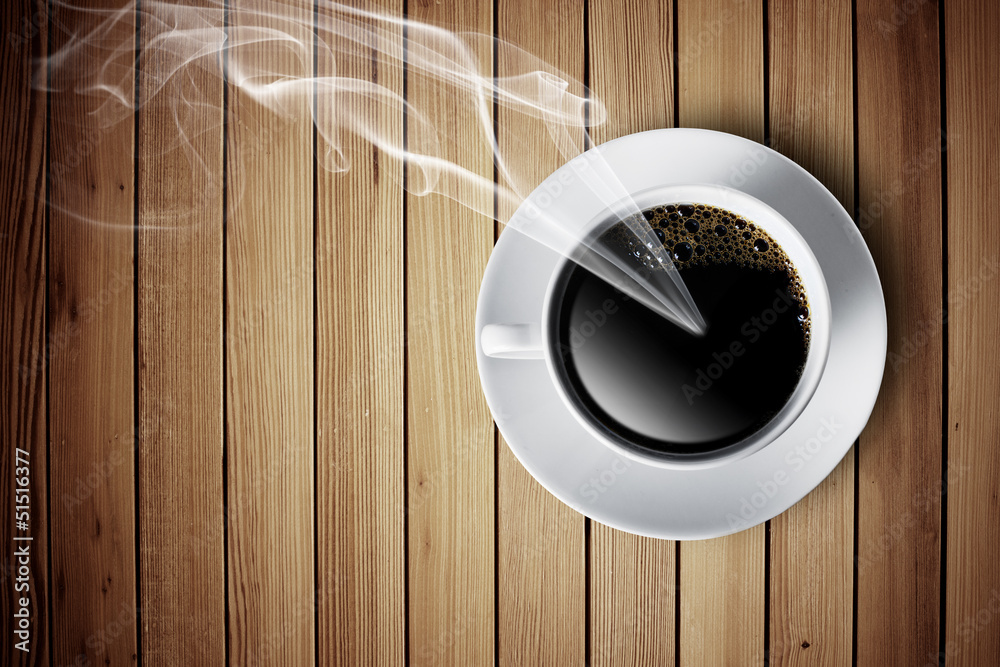 Obraz premium Hot cup of coffee with smoke on wood table